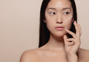 Woman applying cream to face