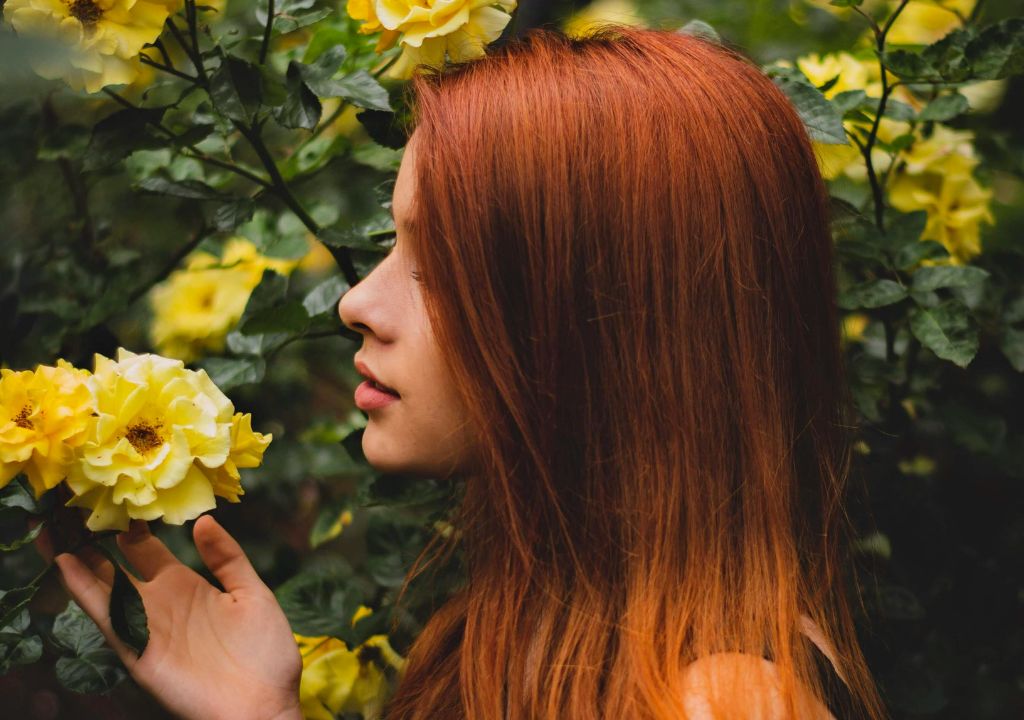lady with auburn hair surrounded by yellow flowers