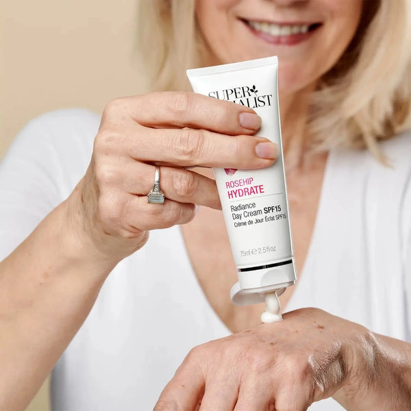 a woman applying the day cream to her hand