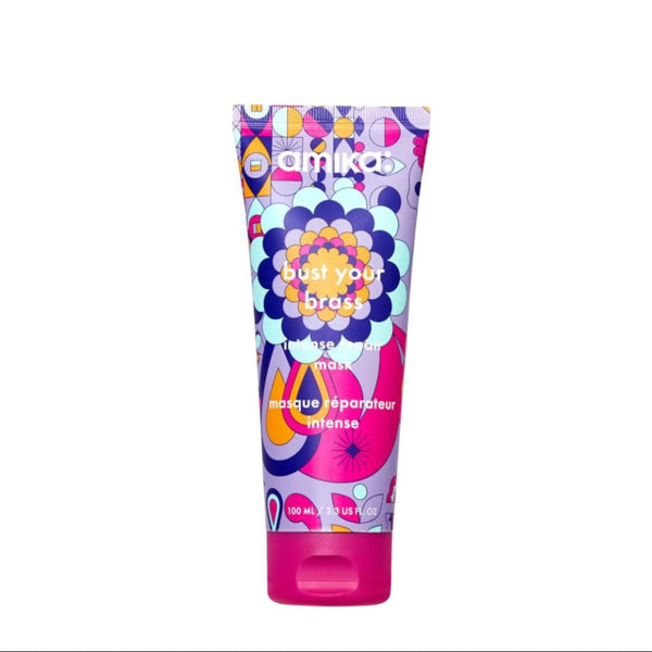 Colorful tube of mika hair product on a white background