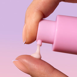 Model applying Sand & Sky Pro Youth Dark Spot Serum to their fingers