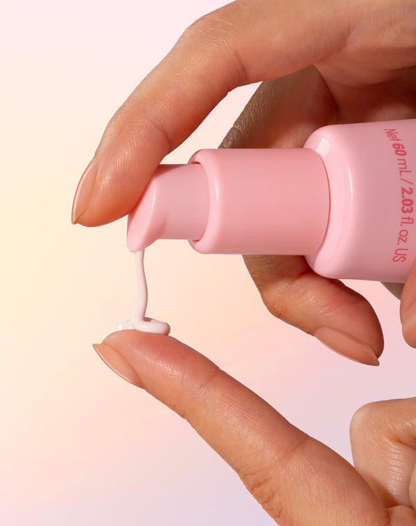 Model applying Sand & Sky Tinted Glow Primer SPF30 to their fingers