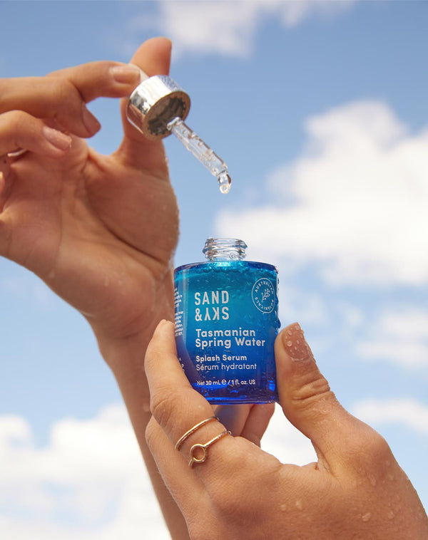 Model taking a few droplets from the Sand & Sky Tasmanian Spring Water Splash Serum bottle