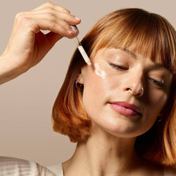 a women applying the serum to her cheek