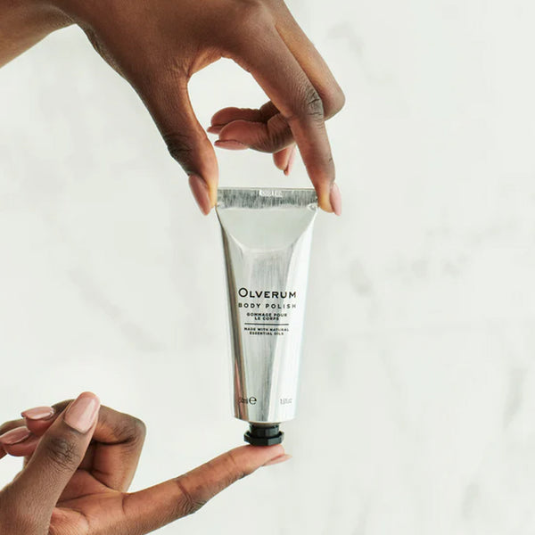 Olverum Body Polish held in the finger tips of a hand