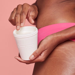 a women holding a tub of Frank Body Perky Sculpting Body Hydrator