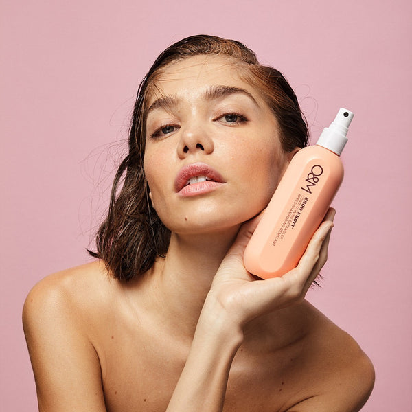 model holding a bottle of O&M Know Knott to her face