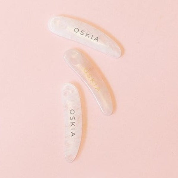 three OSKIA Quartz Spatulas on a pink surface