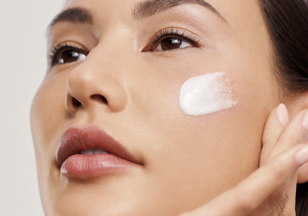 Women applying Augustinus Bader skincare product on her face