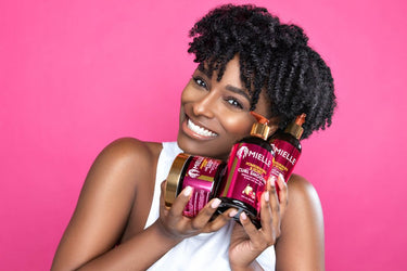 woman with curly hair holding Mielle haircare products