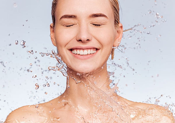 Lady smiling while water splashes her face