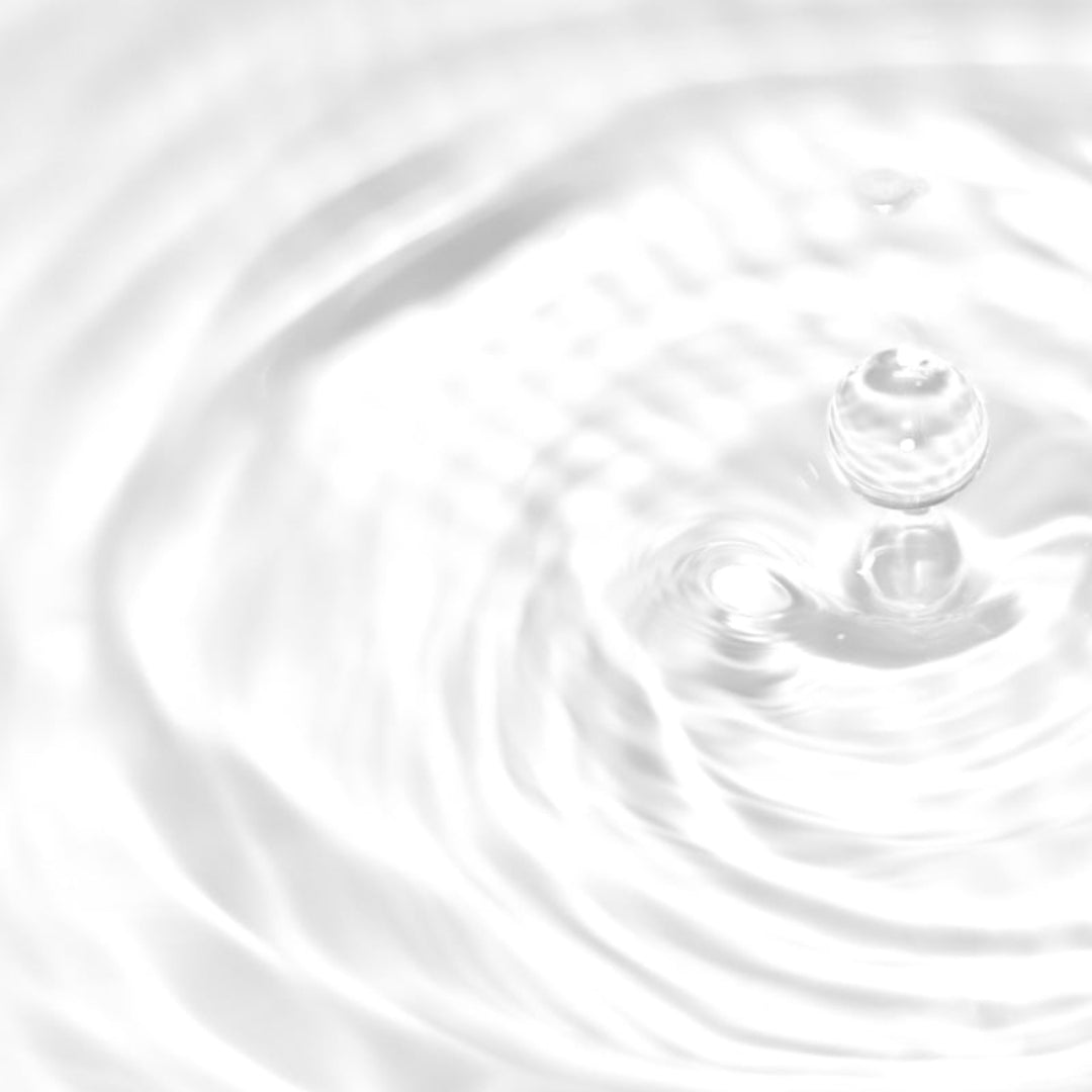 Abstract close-up of clear water ripples with a single droplet suspended above the surface, rendered in bright white and light gray tones.
