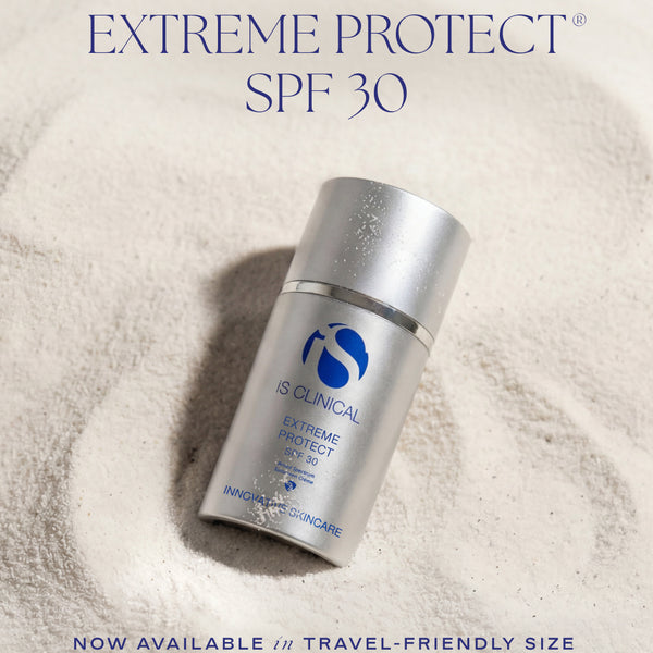 IS Clinical Extreme Protect SPF 30 sunscreen bottle in a silver travel-friendly size, set in a textured white sand-like background with promotional text overlays.
