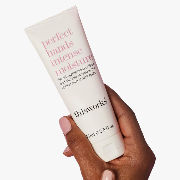 Hand holding a tube of 'this works' perfect hands intense moisture cream against a white background