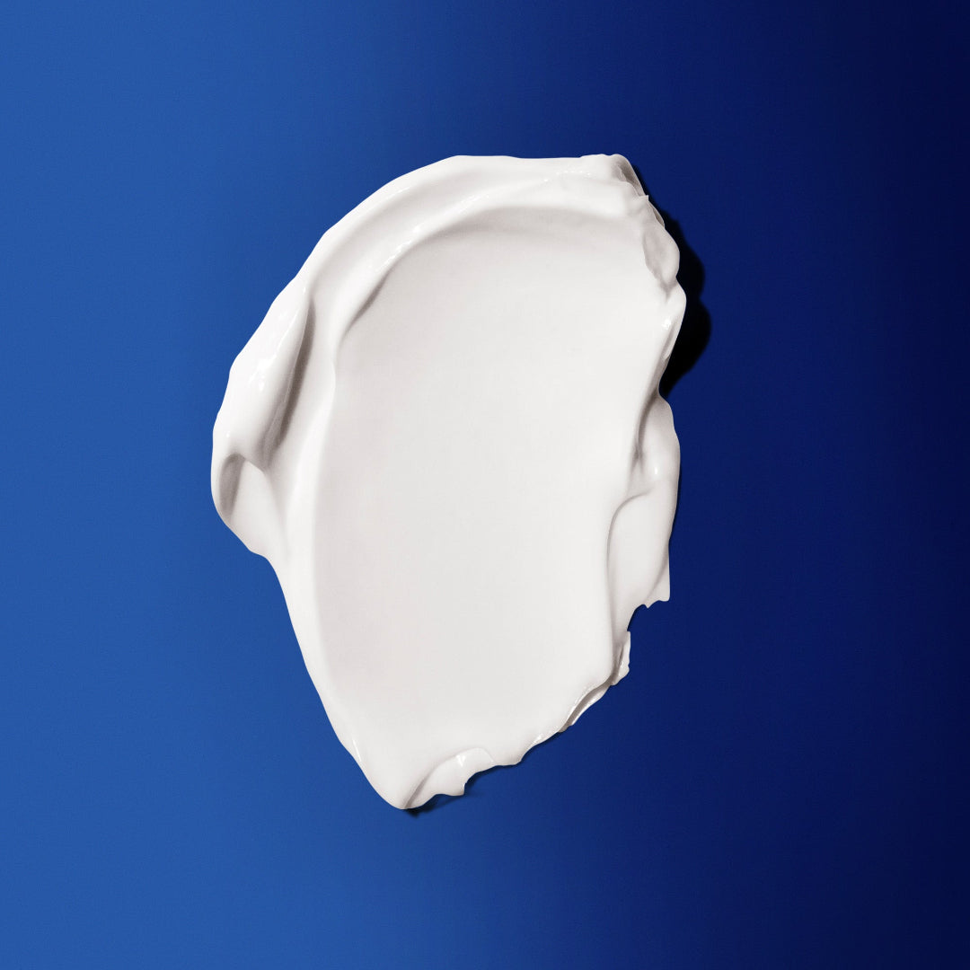 White cream or makeup swatch on a blue background