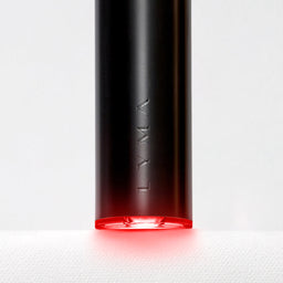 Black cylindrical device with red light on a white background