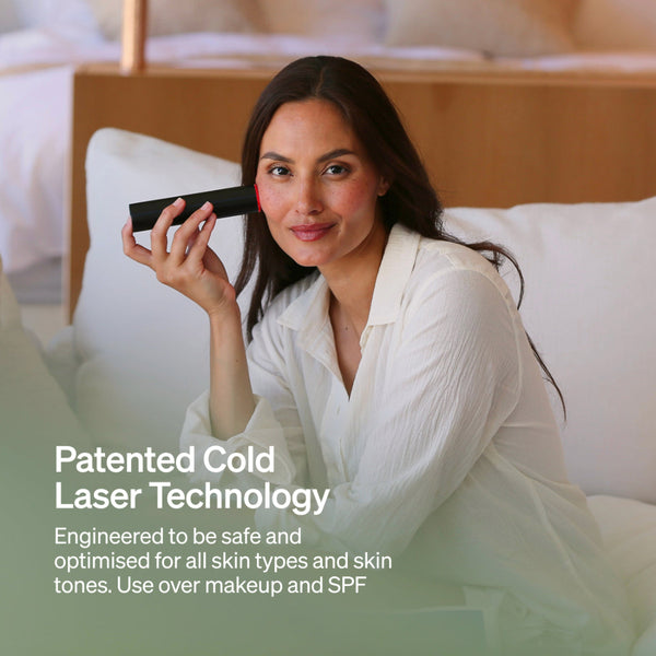 Woman holding a device with text about patented cold laser technology in a bedroom setting