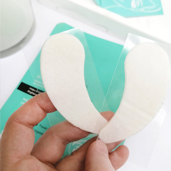 White makeup sponges held by a hand with a blurred background