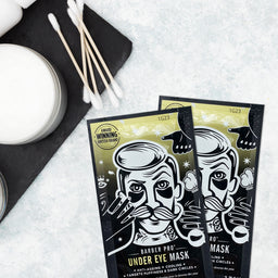 Two Barber Pro under eye mask packages on a textured surface with cotton swabs and a container.