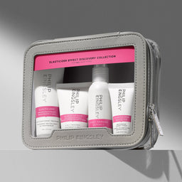 Philip Kingsley Elasticizer Effect Discovery Collection travel kit in a gray zippered pouch with a clear window, containing four white treatment bottles and tubes with pink labels.