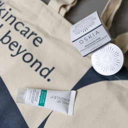 Oskia skincare products on a tote bag with text 'Skincare beyond'.