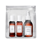 A Sachajuan hair care set in a clear resealable pouch, containing three amber bottles with white caps: conditioner, leave-in conditioner, and moisturizing hair primer, on a white background.