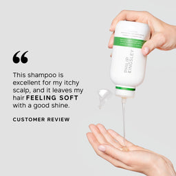 A hand holds a bottle of Philip Kingsley shampoo while another hand receives the clear shampoo gel. The left side features a customer review quote on a light gray background.