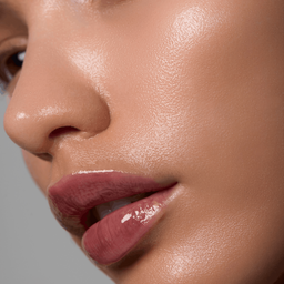 Close-up of a woman's face with a focus on her lips and skin texture.