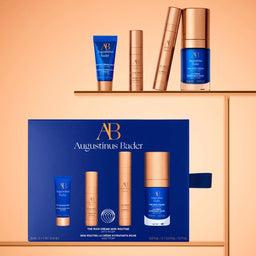 Augustinus Bader skincare products on a peach background with packaging.
