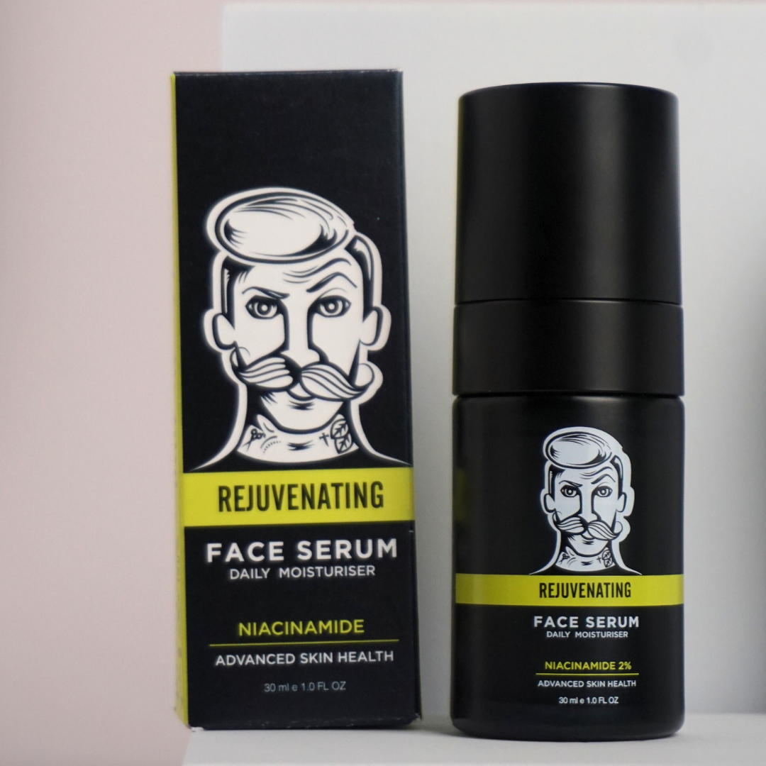Black face serum bottle and packaging with a man's face illustration on a light pink background