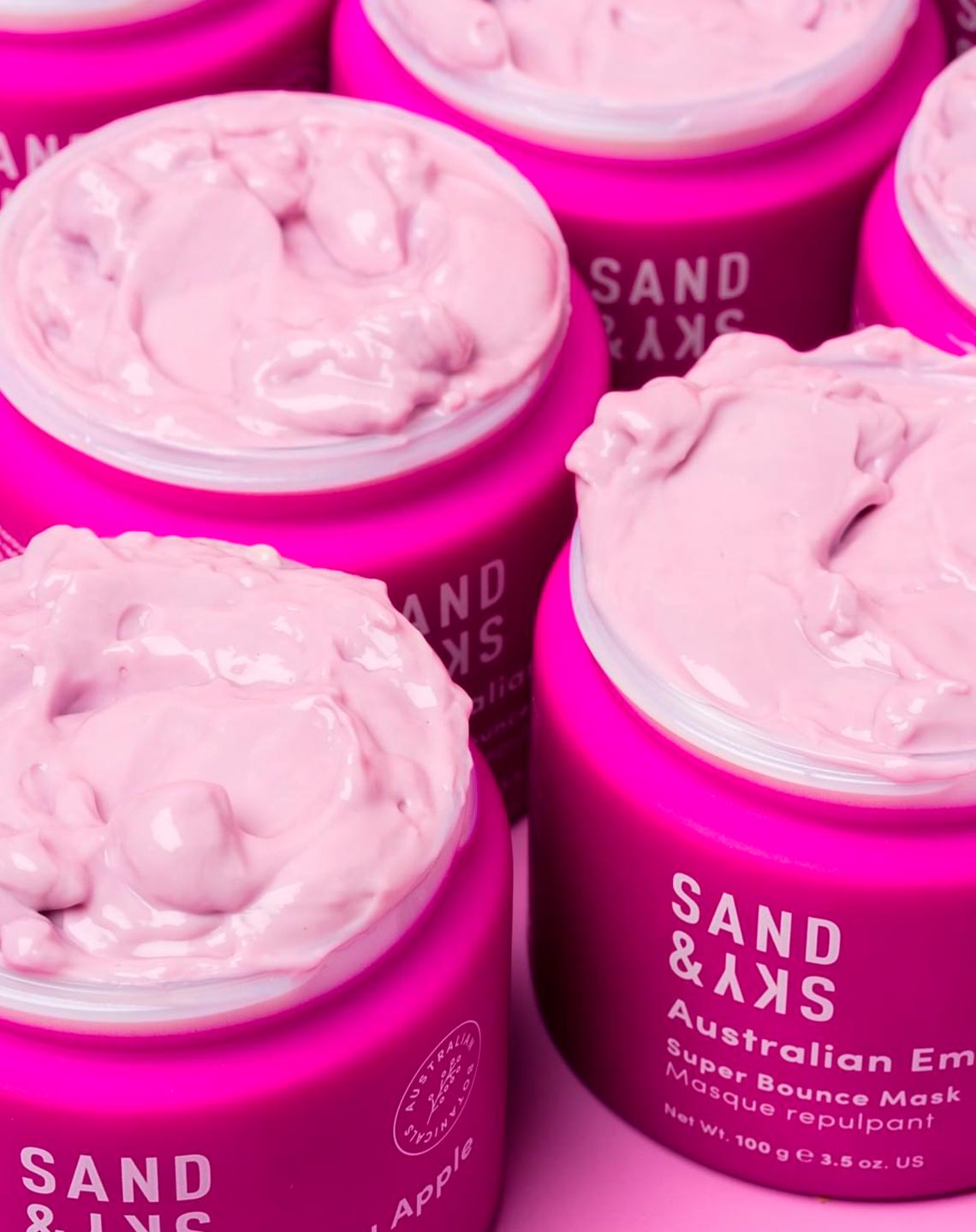 Multiple open tubs of Sand & Sky Australian Emu Apple Super Bounce Mask