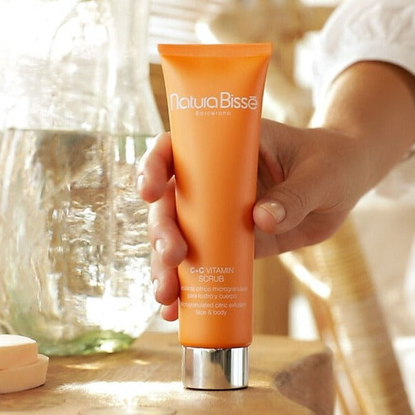 a bottle of Natura Bisse C+C Vitamin Scrub being picked up