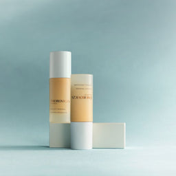 Two cosmetic bottles from the brand ZHAIZHAIYUAN standing on a light blue surface against a soft blue background, with one bottle upright, one lying down, and a rectangular box behind them.