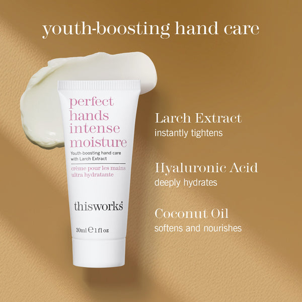 A white tube of thisworks 'perfect hands intense moisture' hand cream is shown on a warm beige textured background with a dollop of the cream above it. Text on the image highlights key ingredients: Larch Extract, Hyaluronic Acid, and Coconut Oil.