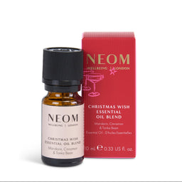 NEOM Christmas Wish Essential Oil Blend in a 10 mL amber glass bottle with a black cap, shown next to its red packaging box on a white background.