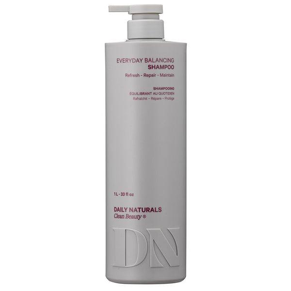 A tall, matte light gray pump bottle of Daily Naturals Everyday Balancing Shampoo on a plain white background.