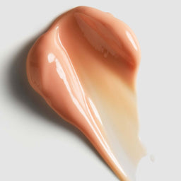 Close-up of a smooth, beige-colored cream on a light gray background