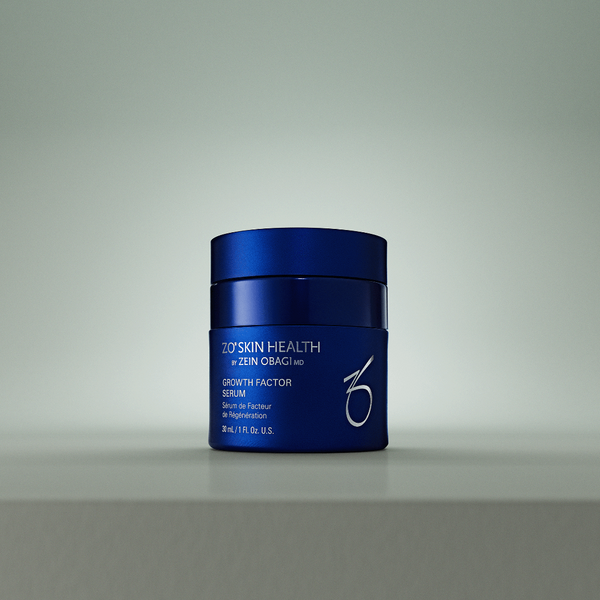 A dark blue cosmetic jar of O'Celeskin Health by Zen-Ohma Growth Factor Serum, centered on a light gray surface against a matching gray background.