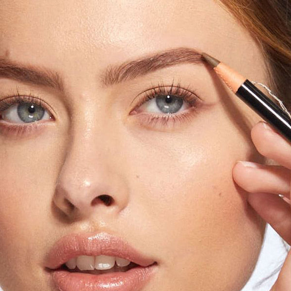 a closeup of a women applying the pencil