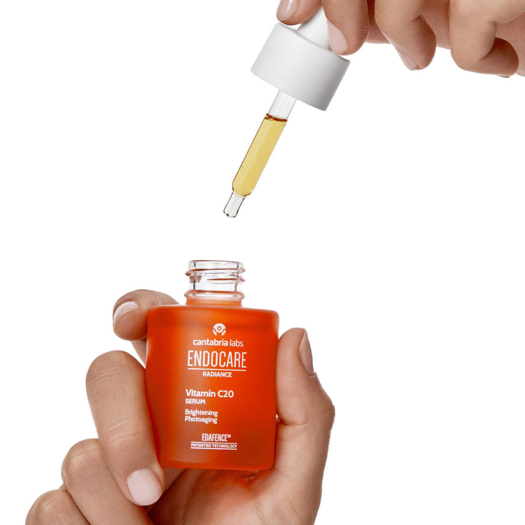 Endocare skincare serum bottle with dropper held by hands on a white background