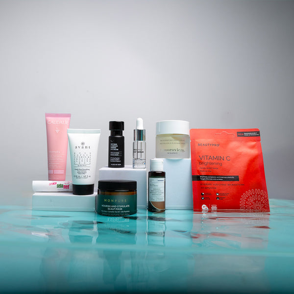 Collection of skincare products on a reflective surface with a gray background