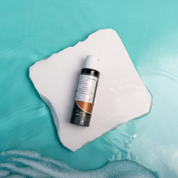 Skincare bottle on a white square with a blue water background
