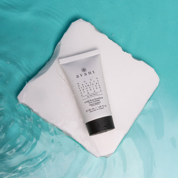 Tube of Avant skincare product on a white towel with a teal water background