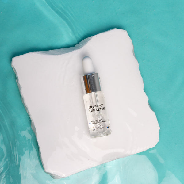 Bioeffect EGF Serum bottle on a white towel with a teal background