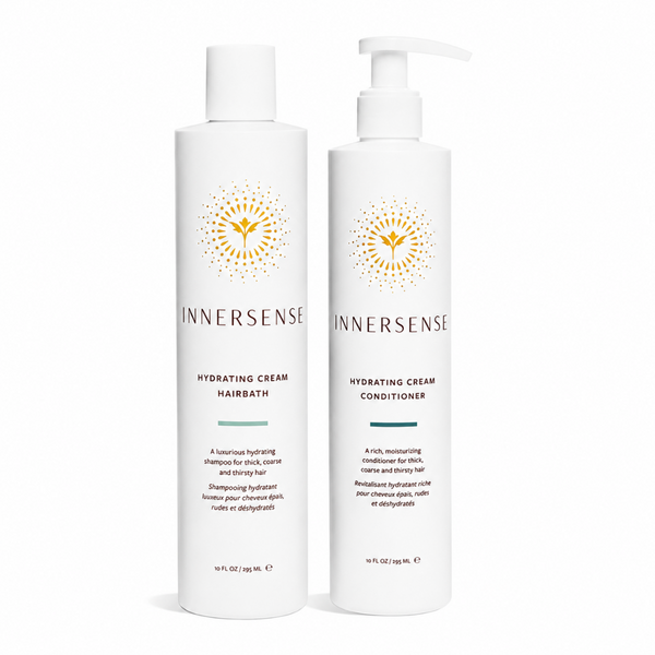 Two white Innersense Hydrating Cream haircare bottles on a clean white background, one with a pump bottle labeled Hairbath and one with a flip-top bottle labeled Conditioner.
