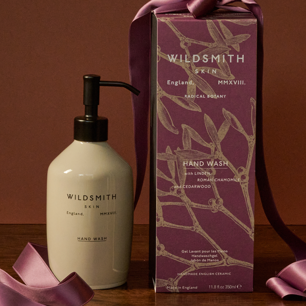 Wildsmith hand wash bottle and packaging on a wooden surface with a brown background