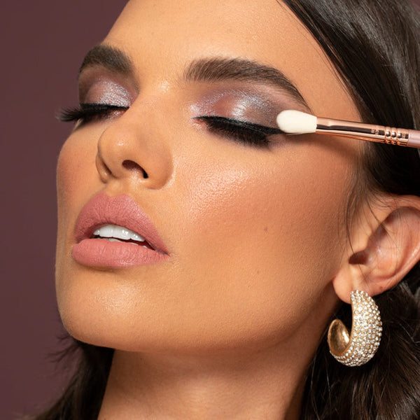 a woman using a brush to apply makeup