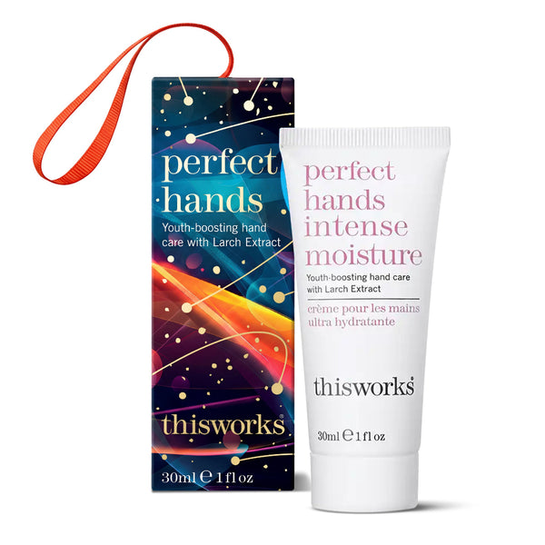 Thisworks Perfect Hands Intense Moisture hand cream 30ml tube next to its colorful packaging box with an orange wrist strap, on a white background.