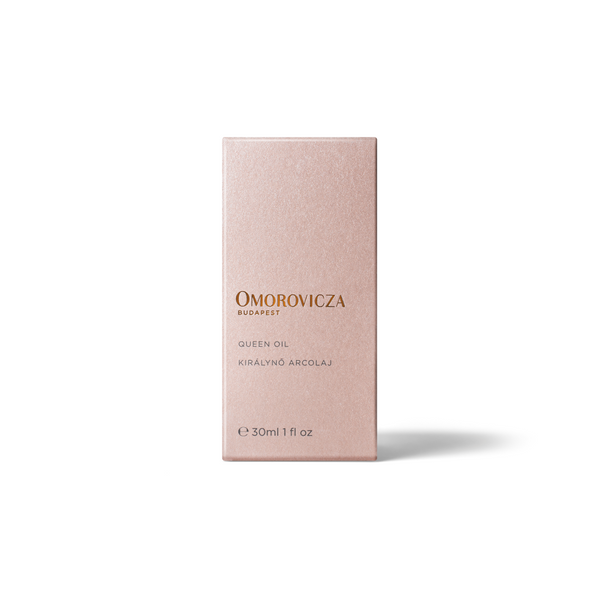 A rectangular pink box for Omorovicza Queen Oil, photographed upright against a clean white background with a soft shadow.