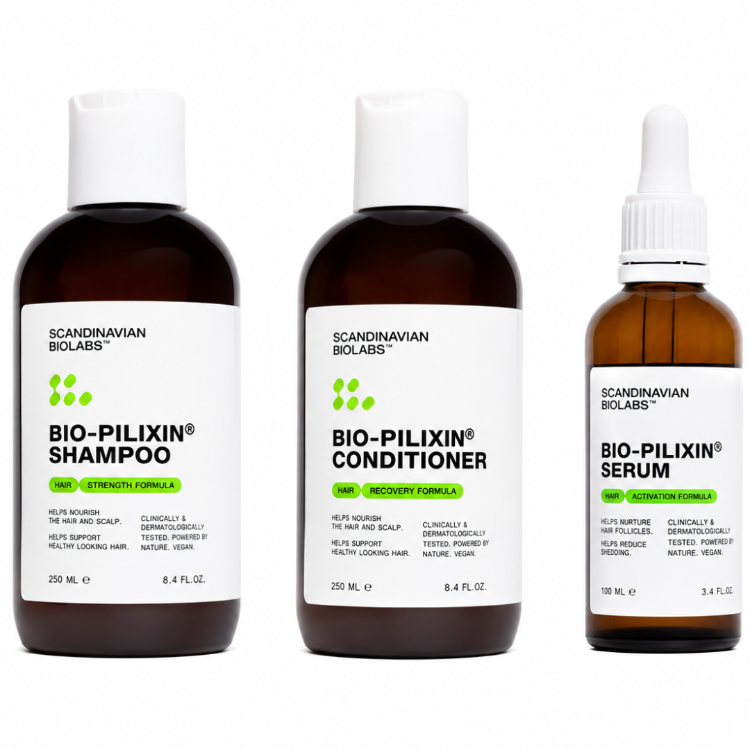 Three Scandinavian Biologs hair care bottles on a white background: Bio-Pilixin Shampoo, Bio-Pilixin Conditioner, and Bio-Pilixin Serum. The larger bottles are dark amber with white caps and white labels, while the serum bottle is smaller and has a white dropper cap.